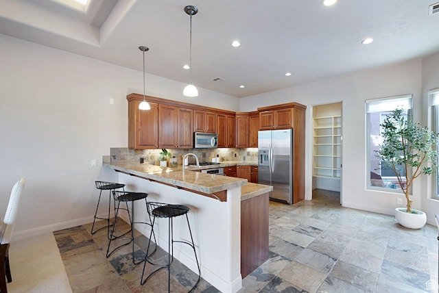 2085 N Tuweap Unit 52, St George, UT 84770 - kitchen featuring tasteful backsplash, decorative light fixtures, a kitchen breakfast bar, kitchen peninsula, and stainless steel appliances