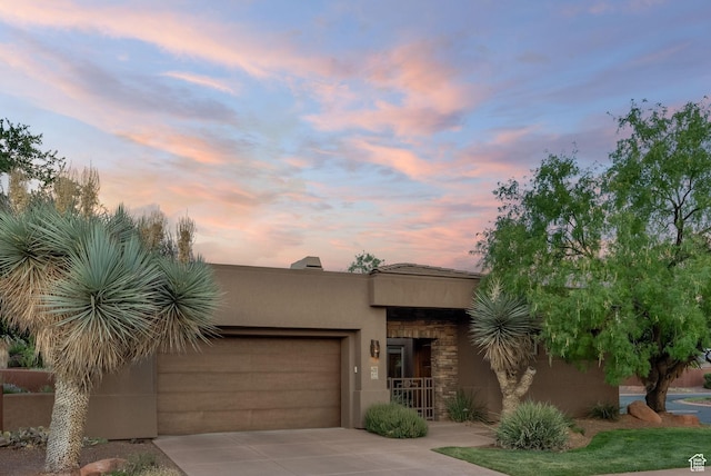 pueblo revival-style home featuring a garage