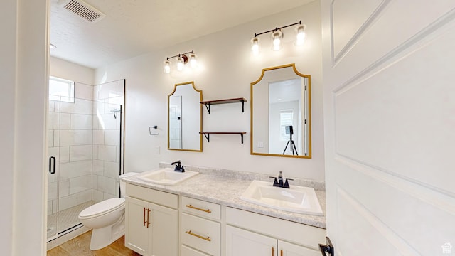 bathroom with wood-type flooring, a baseboard radiator, vanity, an enclosed shower, and toilet
