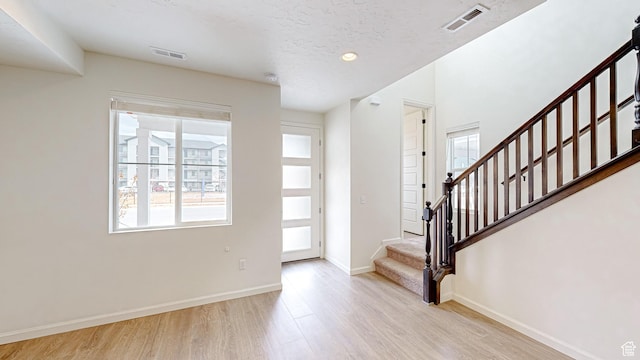 entrance foyer with a wealth of natural light and light hardwood / wood-style floors
