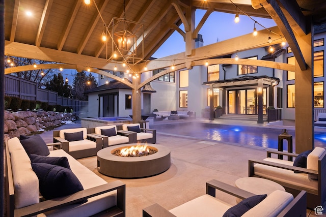 6121 Verness Cv S, Holladay, UT 84121 - patio terrace at dusk with an outdoor structure and an outdoor living space with a fire pit