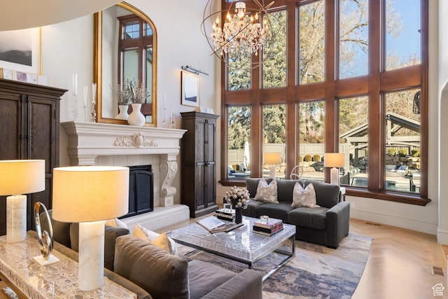 6121 Verness Cv S, Holladay, UT 84121 - living room featuring a chandelier, a towering ceiling, light parquet flooring, and a tiled fireplace