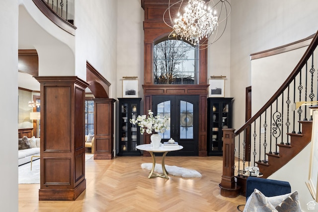 6121 Verness Cv S, Holladay, UT 84121 - entryway with light parquet floors, a high ceiling, a chandelier, and ornate columns