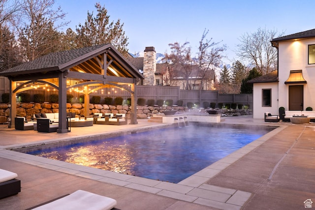 6121 Verness Cv S, Holladay, UT 84121 - pool at dusk with a gazebo, pool water feature, an outdoor hangout area, and a patio