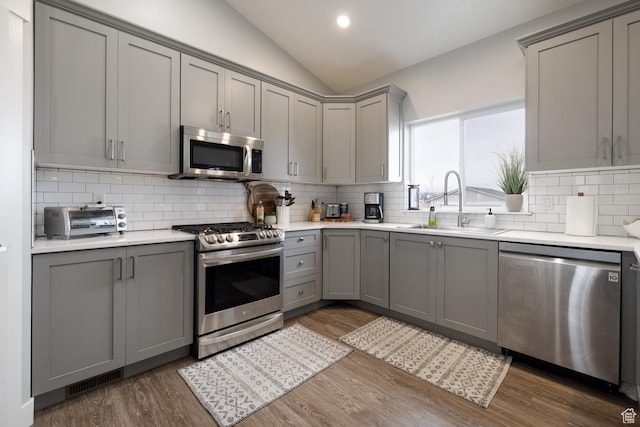 4093 E 4000 S, Vernal, UT 84078 - kitchen with lofted ceiling, sink, appliances with stainless steel finishes, gray cabinetry, and dark hardwood / wood-style flooring
