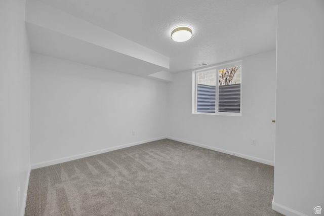 carpeted empty room featuring visible vents, baseboards, and a textured ceiling