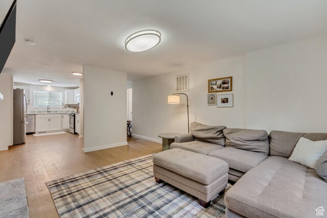 living room with sink and light wood-type flooring