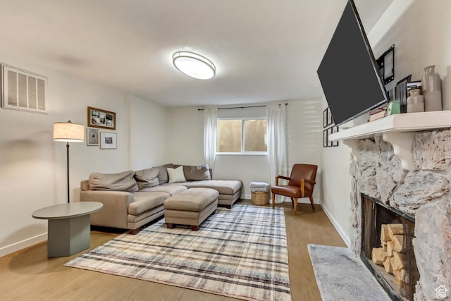 living room featuring wood-type flooring and a fireplace