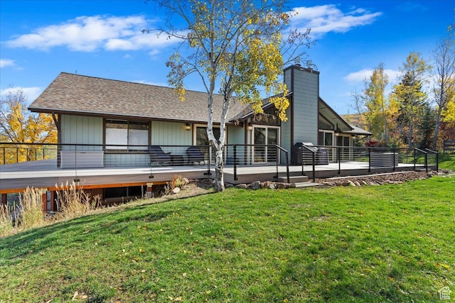 back of property featuring a deck and a lawn