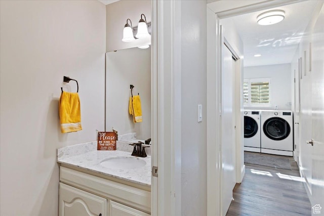 bathroom featuring vanity, wood-type flooring, and washer and dryer