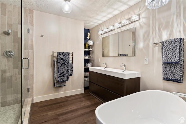 bathroom with wood-type flooring, separate shower and tub, a textured ceiling, and vanity