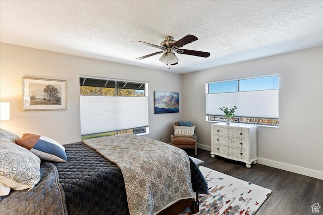 bedroom featuring multiple windows, ceiling fan, dark hardwood / wood-style floors, and a textured ceiling