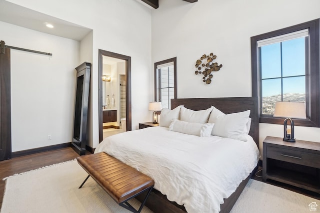 10725 N Hideout Trl, Hideout, UT 84036 - bedroom featuring a barn door, wood finished floors, connected bathroom, and recessed lighting