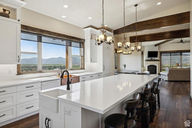 6117 Rocky Ridge Rd N, Peoa, UT 84061 - kitchen featuring sink, white cabinets, a kitchen bar, a mountain view, and a center island with sink