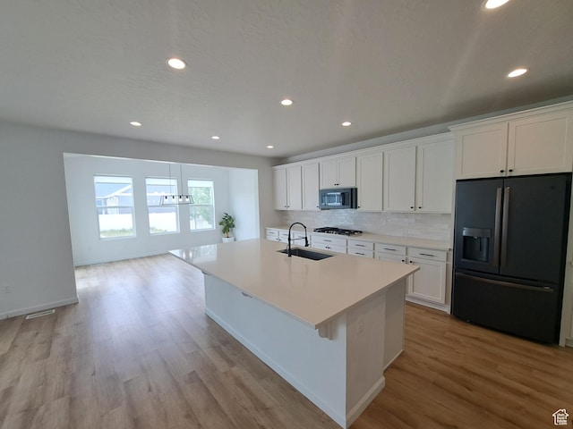 128 Tram Rock Rd, Lake Point, UT 84074 - kitchen featuring black appliances, a sink, a chandelier, light wood-type flooring, and white cabinets