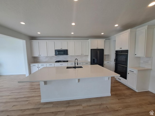 128 Tram Rock Rd, Lake Point, UT 84074 - kitchen with a sink, black appliances, an island with sink, decorative backsplash, and recessed lighting