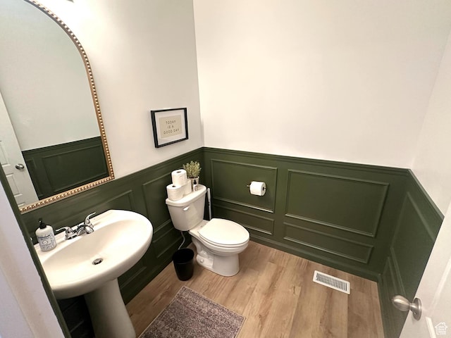 bathroom with toilet and hardwood / wood-style floors