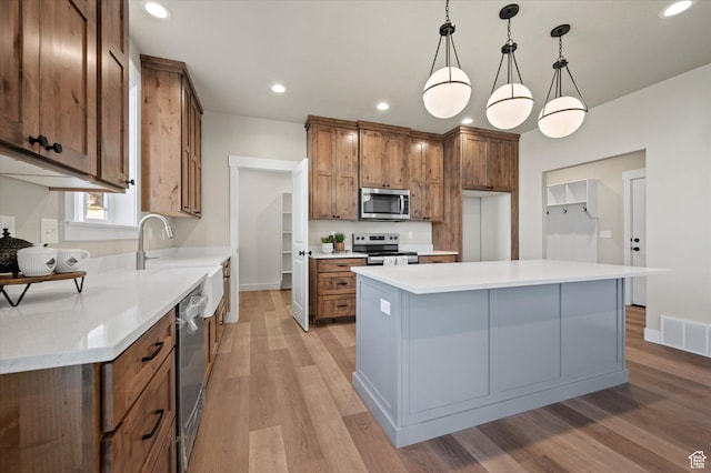 831 E 490 N Unit 143, Hyde Park, UT 84318 - kitchen with sink, hanging light fixtures, light wood-type flooring, appliances with stainless steel finishes, and a kitchen island