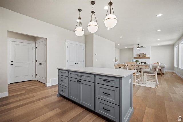 831 E 490 N Unit 143, Hyde Park, UT 84318 - kitchen featuring hanging light fixtures, hardwood / wood-style floors, a kitchen island, and gray cabinetry