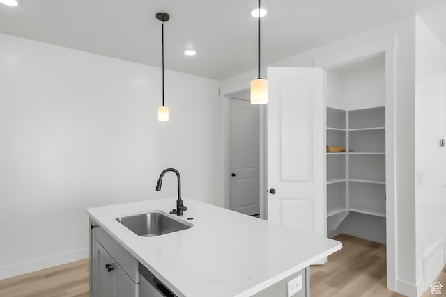 3463 W 3175 N Unit 362, Plain City, UT 84404 - kitchen featuring sink, light hardwood / wood-style flooring, a kitchen island with sink, and decorative light fixtures