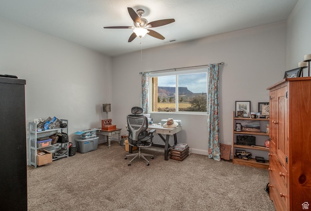 carpeted office featuring a ceiling fan and baseboards
