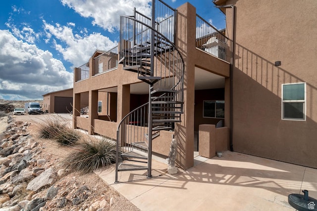 view of side of home with stairway and stucco siding