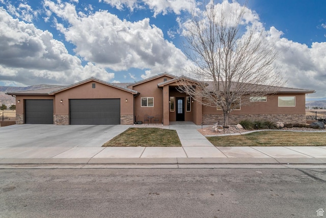 ranch-style home with stone siding, stucco siding, a garage, driveway, and a front lawn