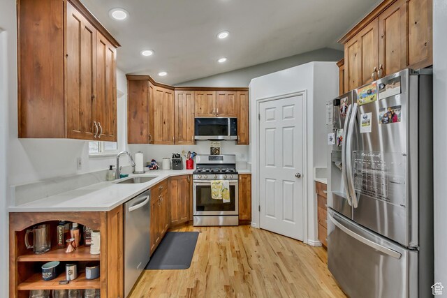 502 N Hidden Cv E, Ogden, UT 84404 - kitchen with lofted ceiling, stainless steel appliances, sink, and light hardwood / wood-style flooring
