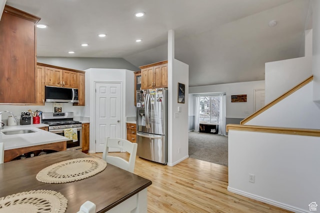502 N Hidden Cv E, Ogden, UT 84404 - kitchen featuring vaulted ceiling, appliances with stainless steel finishes, sink, and light hardwood / wood-style flooring