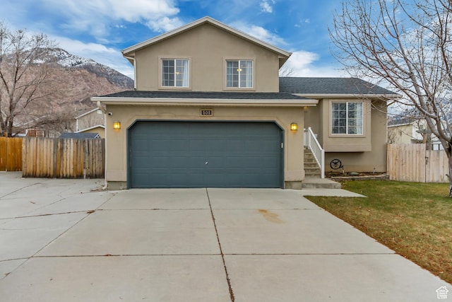 502 N Hidden Cv E, Ogden, UT 84404 - view of front facade featuring a garage, a mountain view, and a front lawn