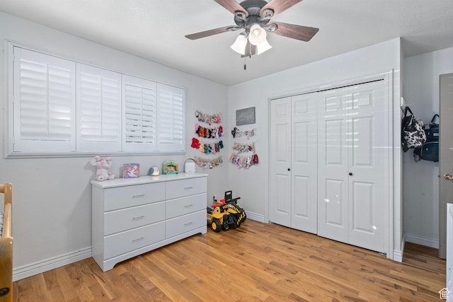 bedroom with light wood-style floors, baseboards, a ceiling fan, and a closet