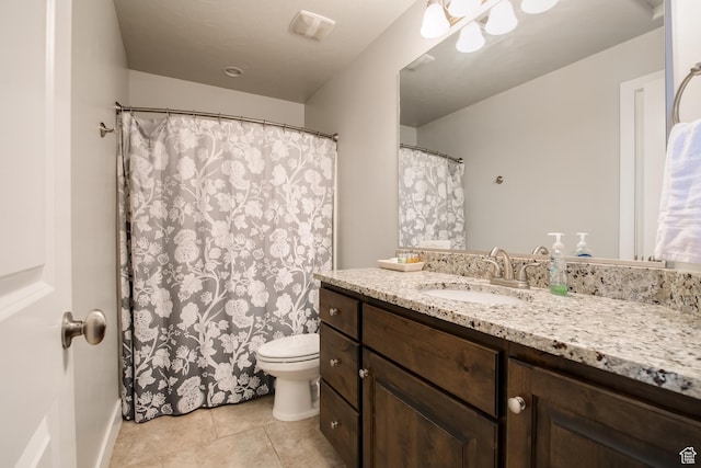 bathroom with tile patterned flooring, vanity, and toilet