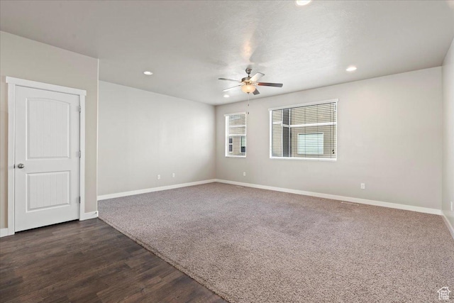 empty room featuring dark hardwood / wood-style flooring and ceiling fan