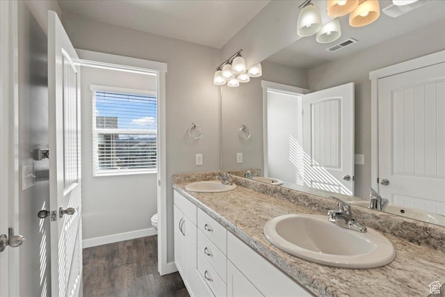 bathroom with wood-type flooring, toilet, and vanity