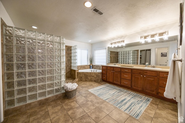1903 W Wild Wood Ct N, Lehi, UT 84043 - bathroom with tiled tub, vanity, tile patterned floors, and a textured ceiling