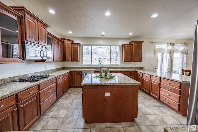 1903 W Wild Wood Ct N, Lehi, UT 84043 - kitchen featuring light tile patterned flooring, appliances with stainless steel finishes, a center island, and kitchen peninsula