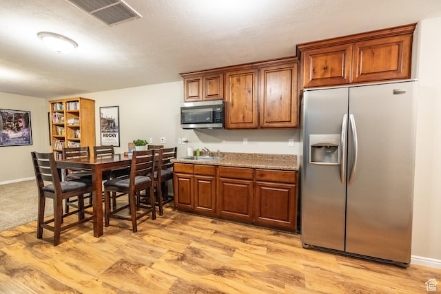 1903 W Wild Wood Ct N, Lehi, UT 84043 - kitchen with light stone counters, stainless steel appliances, sink, and light wood-type flooring