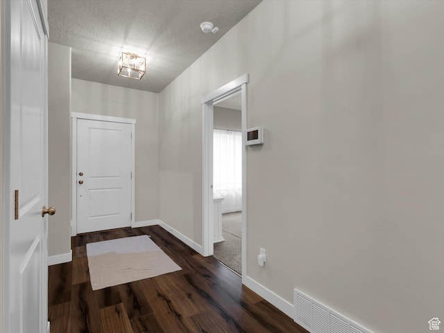 entrance foyer with a textured ceiling and dark hardwood / wood-style flooring