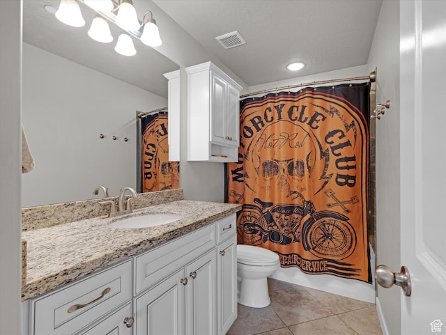 bathroom featuring tile patterned floors, toilet, vanity, and a textured ceiling
