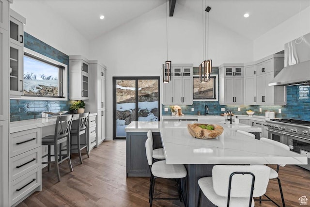 11432 N Fox Hollow Ct Unit 121, Hideout, UT 84036 - kitchen with dark wood-type flooring, a breakfast bar, light stone counters, a wealth of natural light, and wall chimney range hood