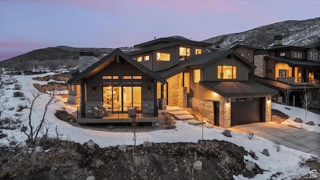 11432 N Fox Hollow Ct Unit 121, Hideout, UT 84036 - snow covered property with a mountain view, driveway, stone siding, and a garage