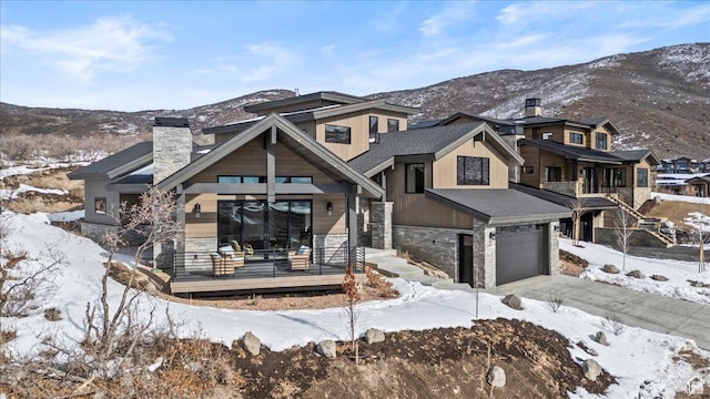 11432 N Fox Hollow Ct Unit 121, Hideout, UT 84036 - view of front facade with driveway, stone siding, a chimney, a garage, and a mountain view