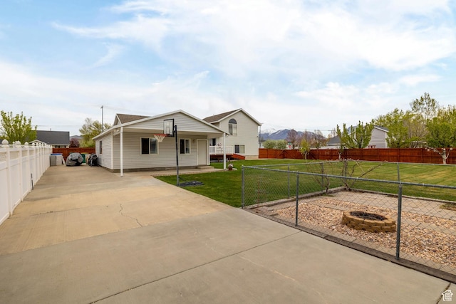 view of front of house featuring a fenced backyard, driveway, and a front lawn