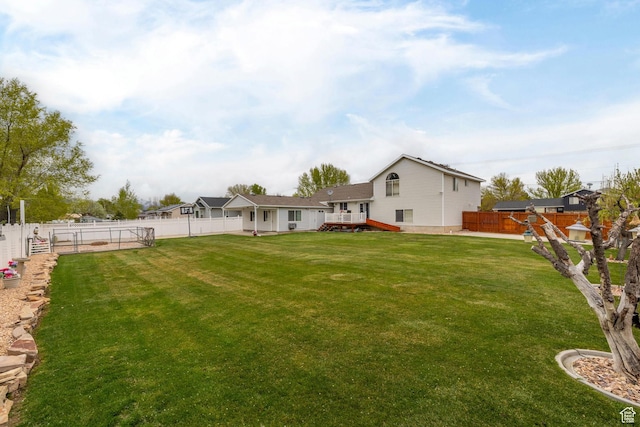 view of yard with a wooden deck and a fenced backyard