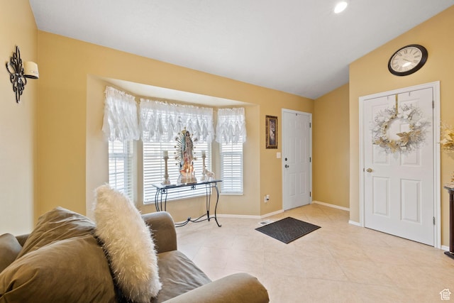 foyer entrance with lofted ceiling, baseboards, and light tile patterned floors