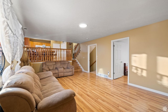 living room featuring recessed lighting, stairway, visible vents, light wood-style floors, and baseboards