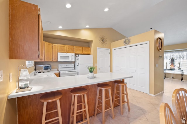 kitchen with a sink, white appliances, light tile patterned floors, light countertops, and a peninsula