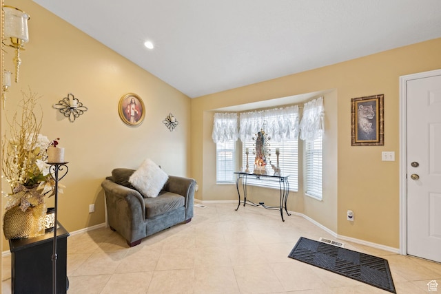 sitting room featuring light tile patterned flooring, vaulted ceiling, baseboards, visible vents, and recessed lighting