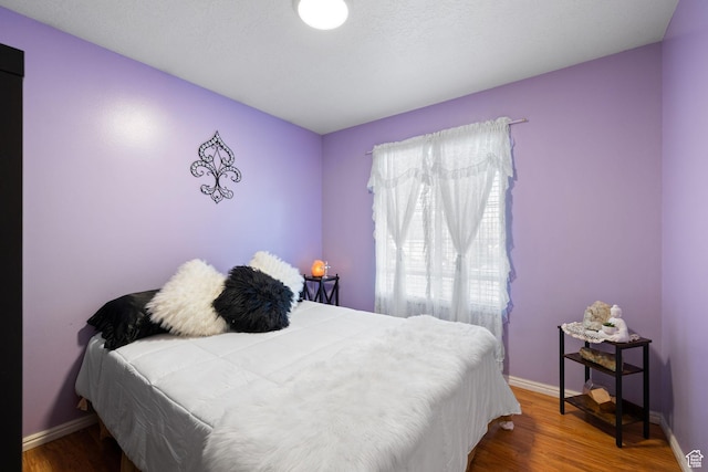 bedroom featuring wood finished floors and baseboards
