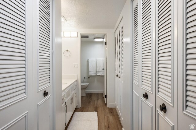 245 N Vine St W Unit 501, Salt Lake City, UT 84103 - bathroom with hardwood / wood-style flooring, vanity, toilet, and a textured ceiling